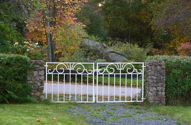 White metal garden gate between stone posts in Klavreström, Sweden, photographed in October 2006