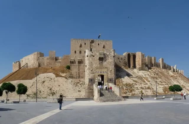 The Citadel of Aleppo entrance bridge and fortified gateway above its sloping mound, photographed in 2010.