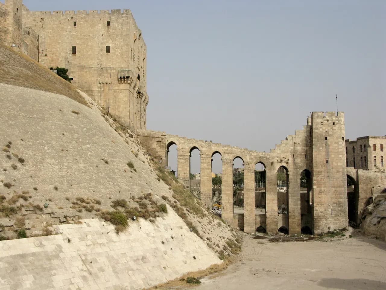 Archive view of the Citadel of Aleppo stone-faced slope and arched entrance bridge, photographed by Vyacheslav Argenberg on 21 August 2008.