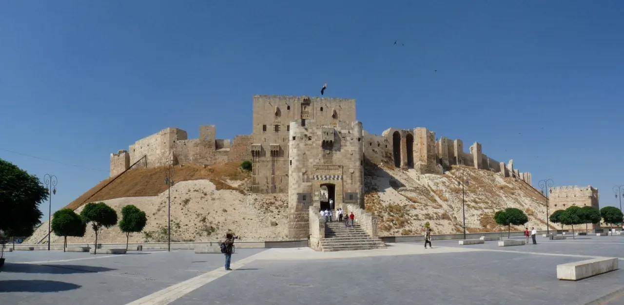 The Citadel of Aleppo entrance bridge and fortified gateway above its sloping mound, photographed in 2010.