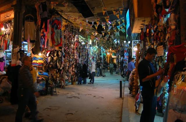 Covered market passage in Aleppo with shop displays and pedestrians, photographed in April 2008