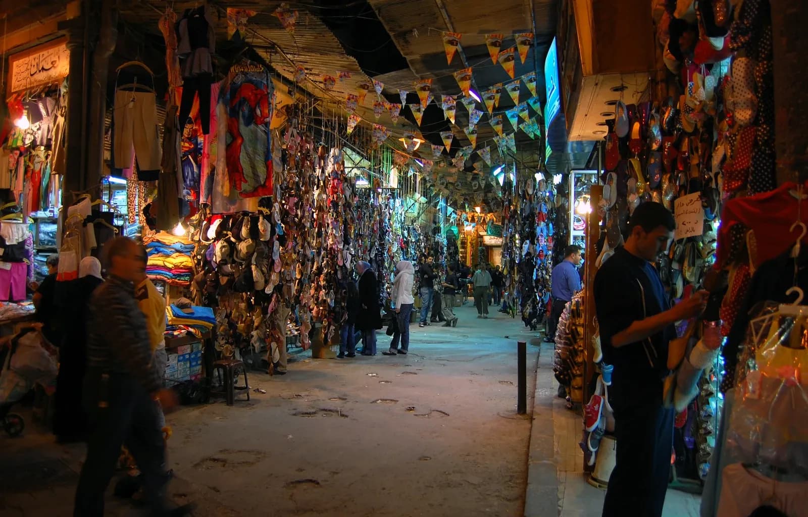 Covered market passage in Aleppo with shop displays and pedestrians, photographed in April 2008