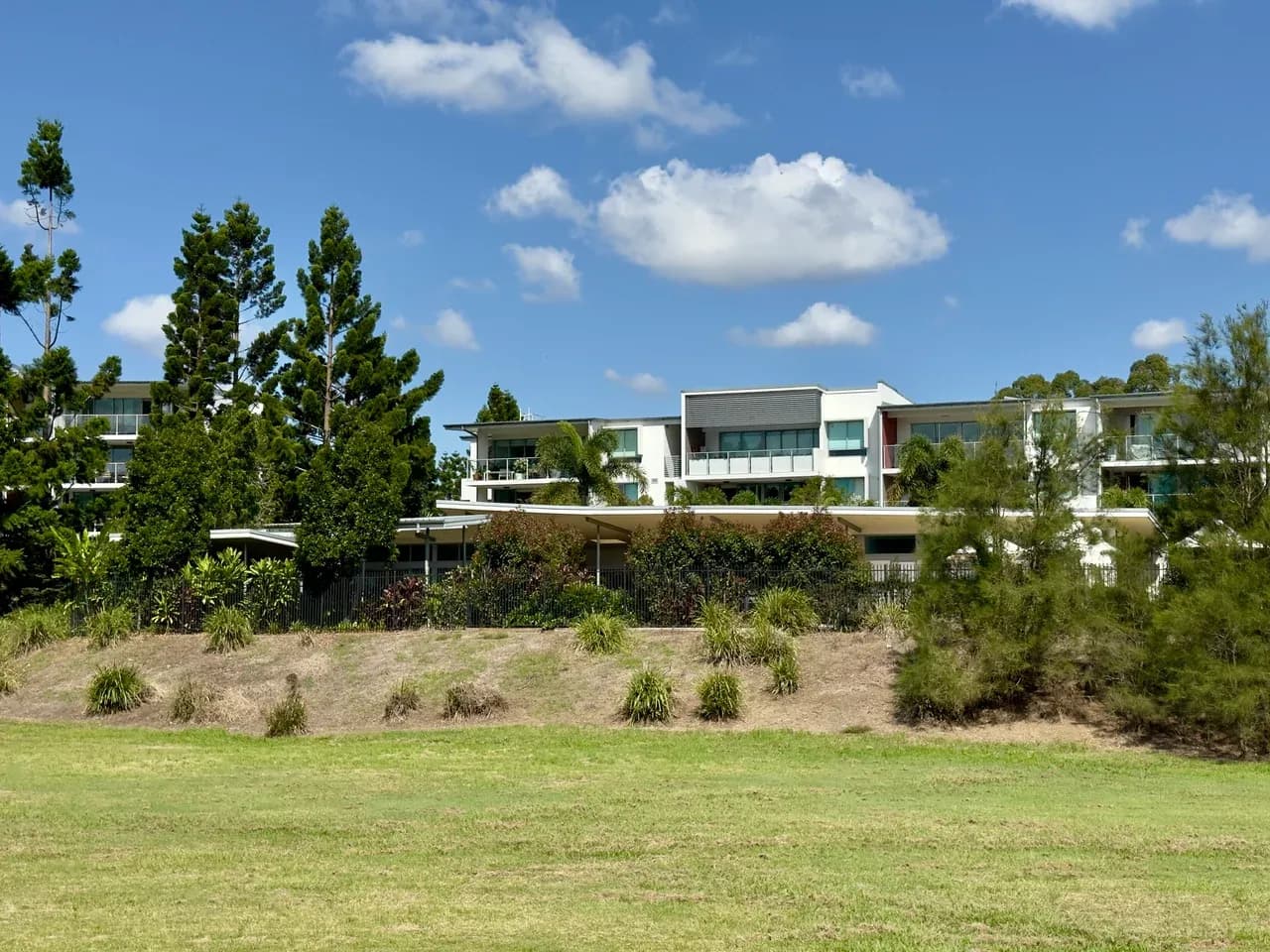 Apartment-building exterior with balconies, trees and planted grounds in Sherwood, Brisbane, Australia