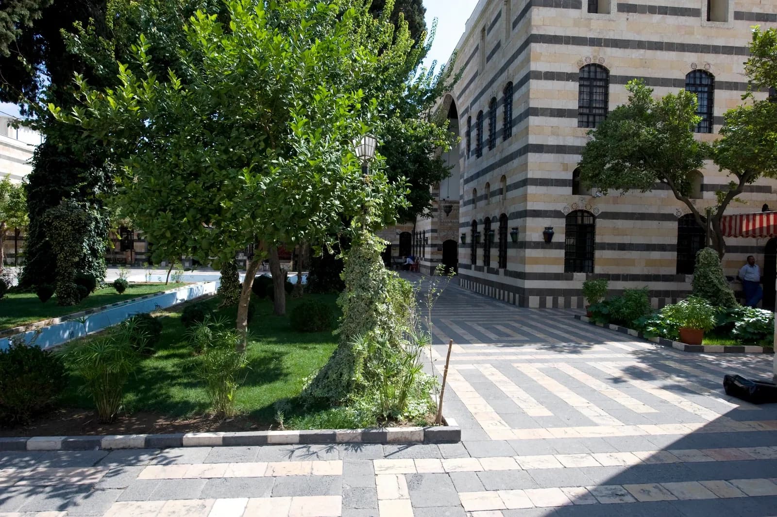 Garden edge and paved route beside the enclosing facades of Azem Palace courtyard, Damascus, September 2008
