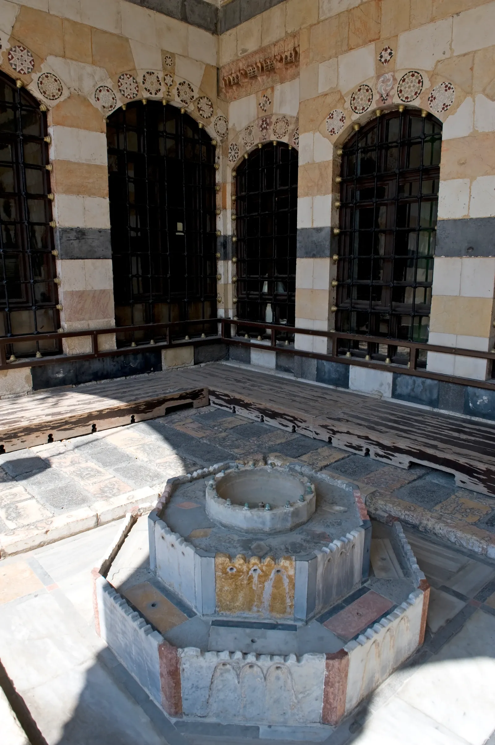 Banded walls, grilled arched windows and a fountain in the Azem Palace porch, Damascus, September 2008
