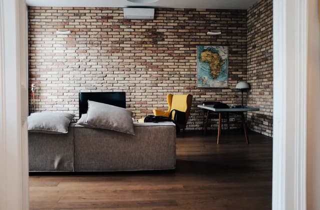 Furnished Budapest apartment seen through a doorway, with a sofa, armchair and table defining the living area