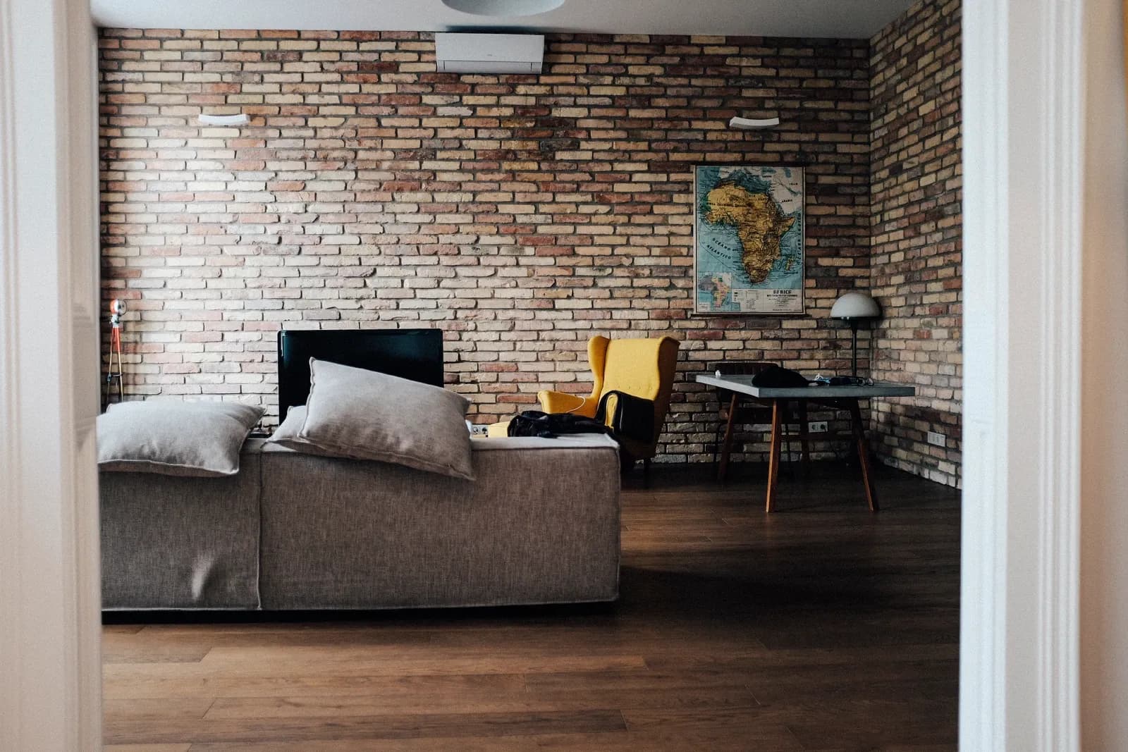 Furnished Budapest apartment seen through a doorway, with a sofa, armchair and table defining the living area