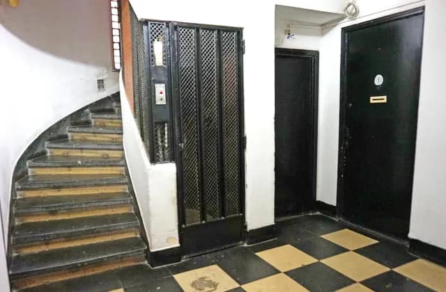 Stairs, an enclosed lift and apartment entrance doors in a building in Bucharest, Romania