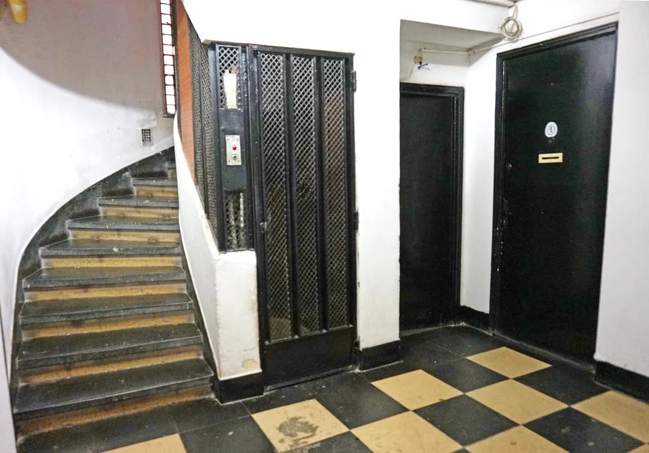 Stairs, an enclosed lift and apartment entrance doors in a building in Bucharest, Romania