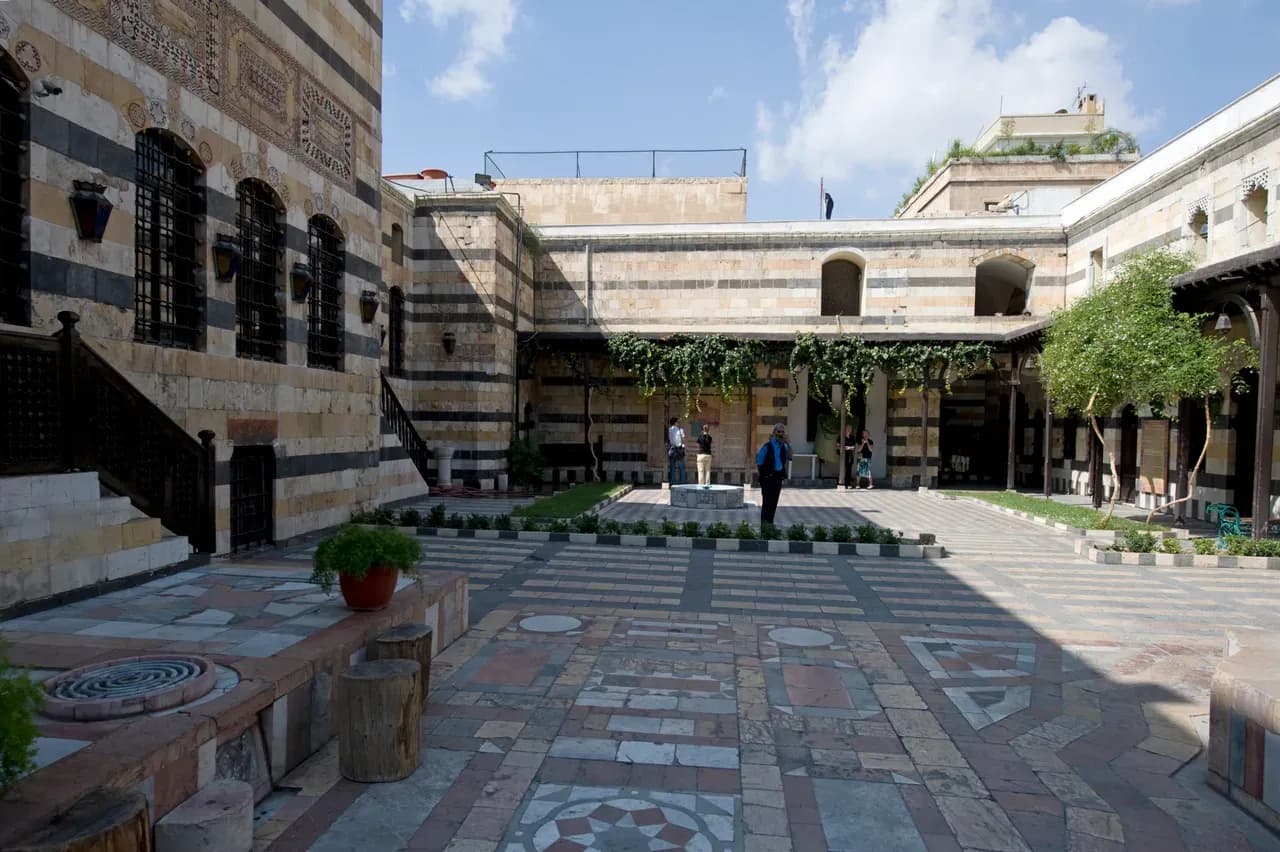 An archive view across the paved Azem Palace courtyard in Damascus towards its shaded porch, photographed in 2008.