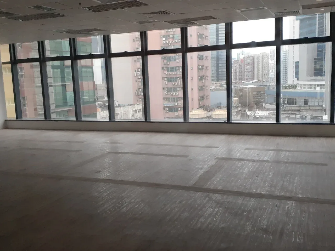 Unfurnished office with broad windows and a view of nearby buildings in Kwun Tong, Hong Kong