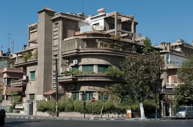 Balconies and green shutters on a corner building on Al-Jalaa Street in Damascus, photographed in October 2010