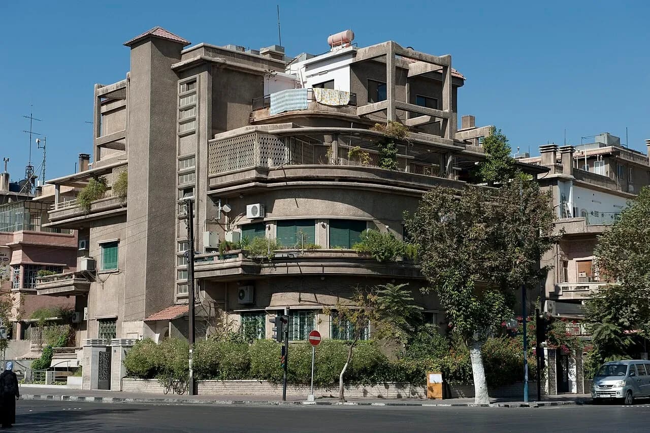 Balconies and green shutters on a corner building on Al-Jalaa Street in Damascus, photographed in October 2010