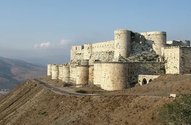 Stone towers of Crac des Chevaliers above a rural hill landscape, August 2008 archive photograph