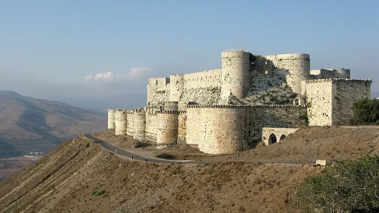 Stone towers of Crac des Chevaliers above a rural hill landscape, August 2008 archive photograph