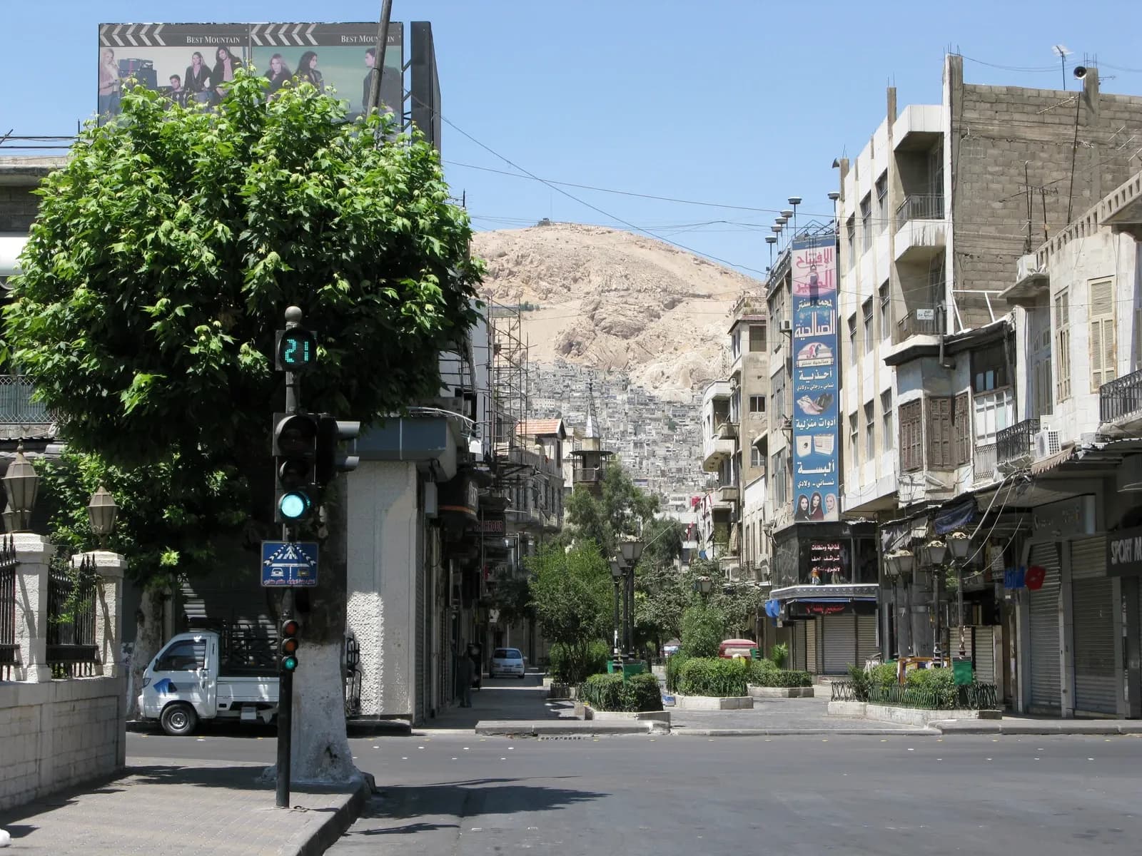 Street frontages and a traffic light in central Damascus, with Mount Qasioun in the distance, August 2008