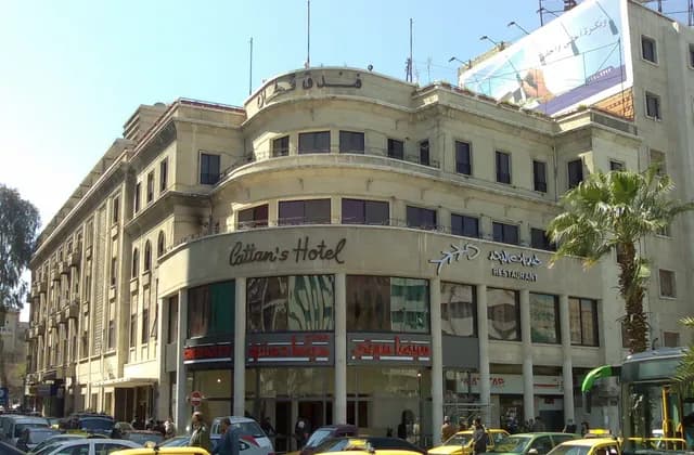 Corner frontage of Cattan's Hotel beside vehicles in Damascus, March 2009