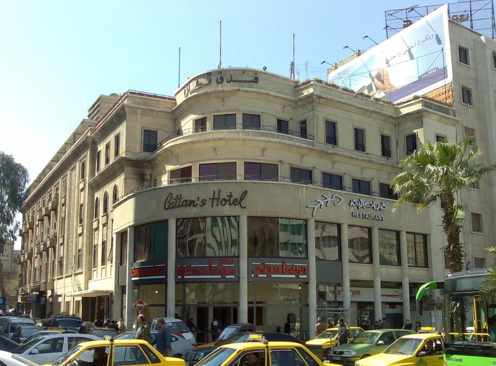 Corner frontage of Cattan's Hotel beside vehicles in Damascus, March 2009