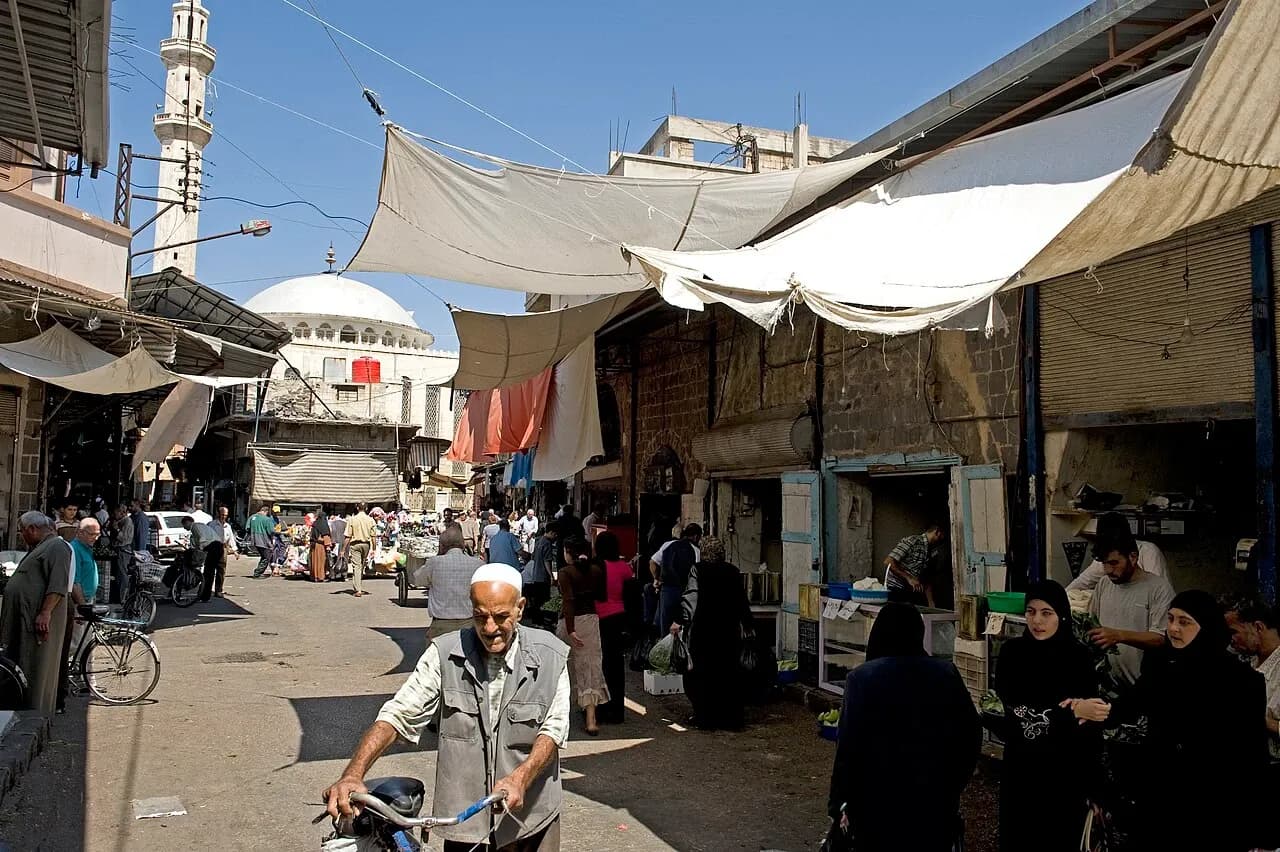 Pedestrians, shopfronts and shade cloths on a Homs street, September 2008
