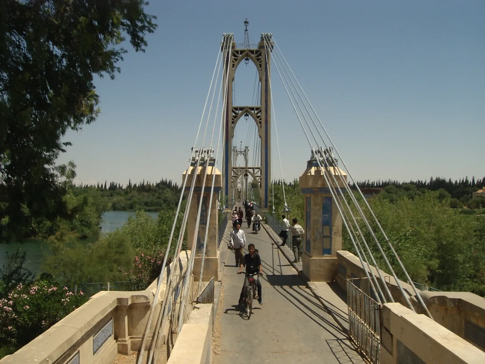 Pedestrians and a cyclist on Deir ez-Zor suspension bridge over the Euphrates in a 2008 archive photograph
