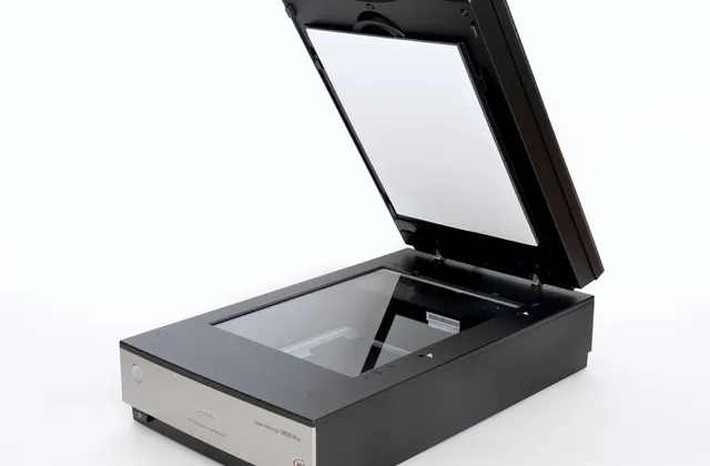 Open flatbed scanner with its lid raised and glass bed visible, photographed in September 2023
