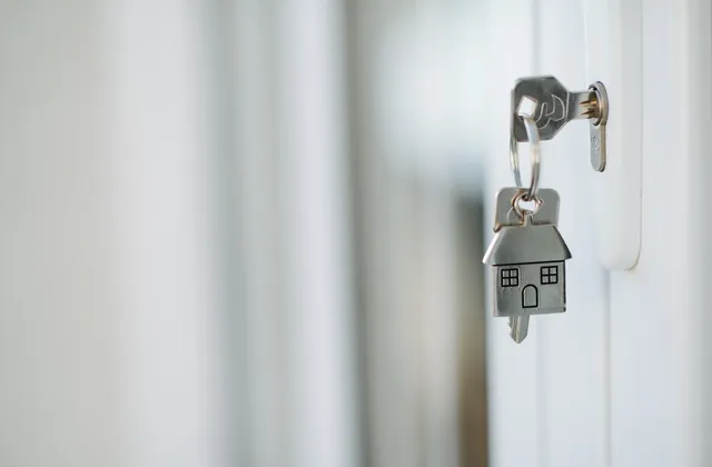 Key in a door lock with a house-shaped keyring, photographed in October 2021