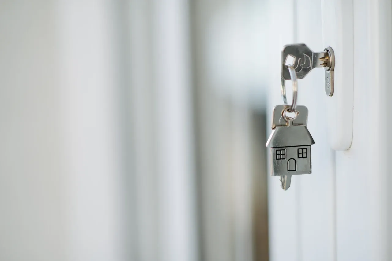 Key in a door lock with a house-shaped keyring, photographed in October 2021