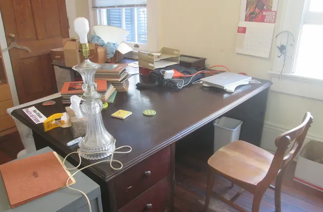 Large wooden desk and chair occupying a home office beside windows in Carrollton, New Orleans, February 2016