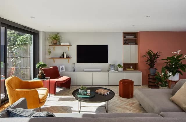 Furnished living room with seating, fitted storage, plants and glazed garden doors