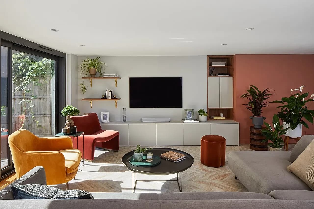 Furnished living room with seating, fitted storage, plants and glazed garden doors