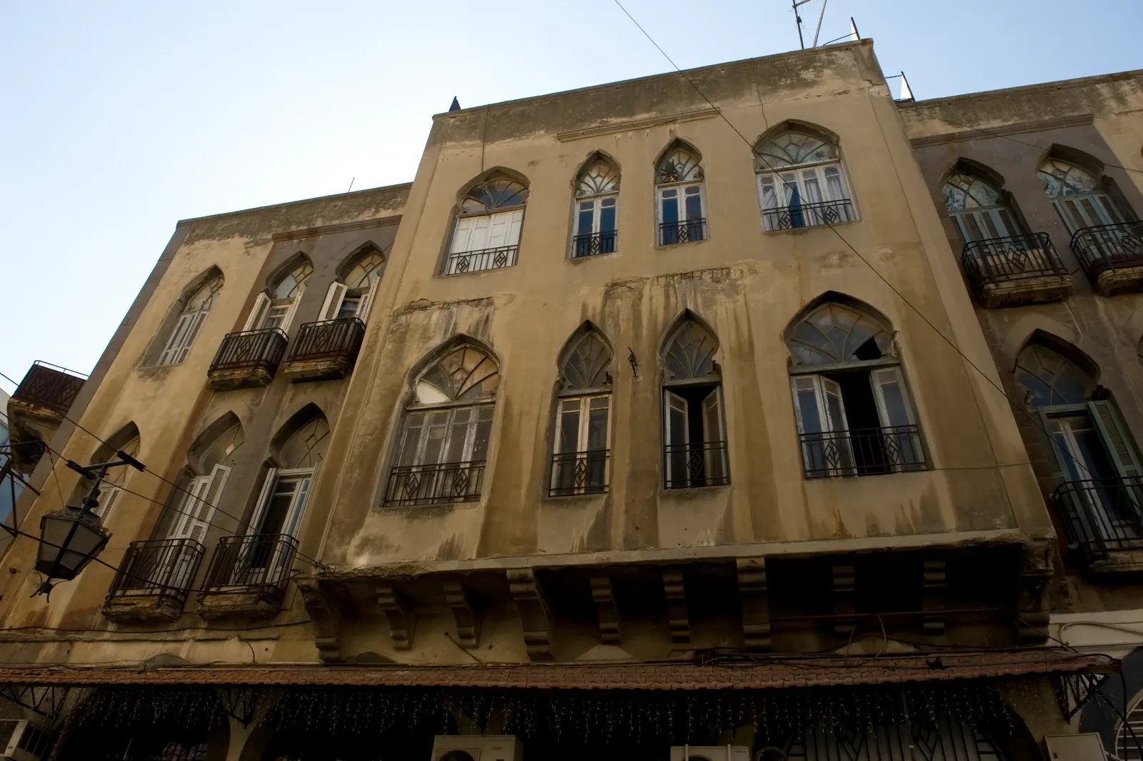 Arched windows and small projecting balconies on a Homs building facade, photographed in September 2008