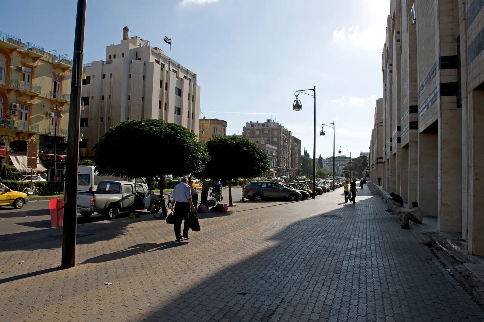 Pedestrians, buildings and a broad sidewalk in Homs, September 2008