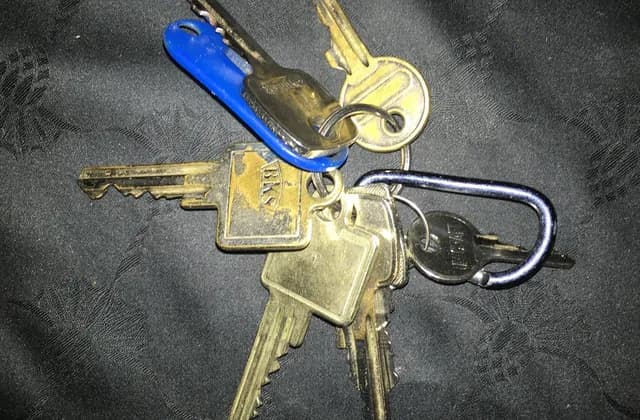 Several metal keys and a blue plastic tag on a keyring, photographed in November 2022