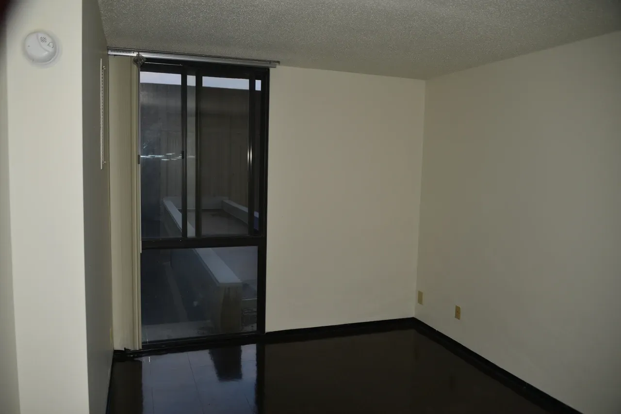 Unfurnished room with a tall glazed opening and bare walls at Riverside Plaza in Minneapolis, photographed in August 2014