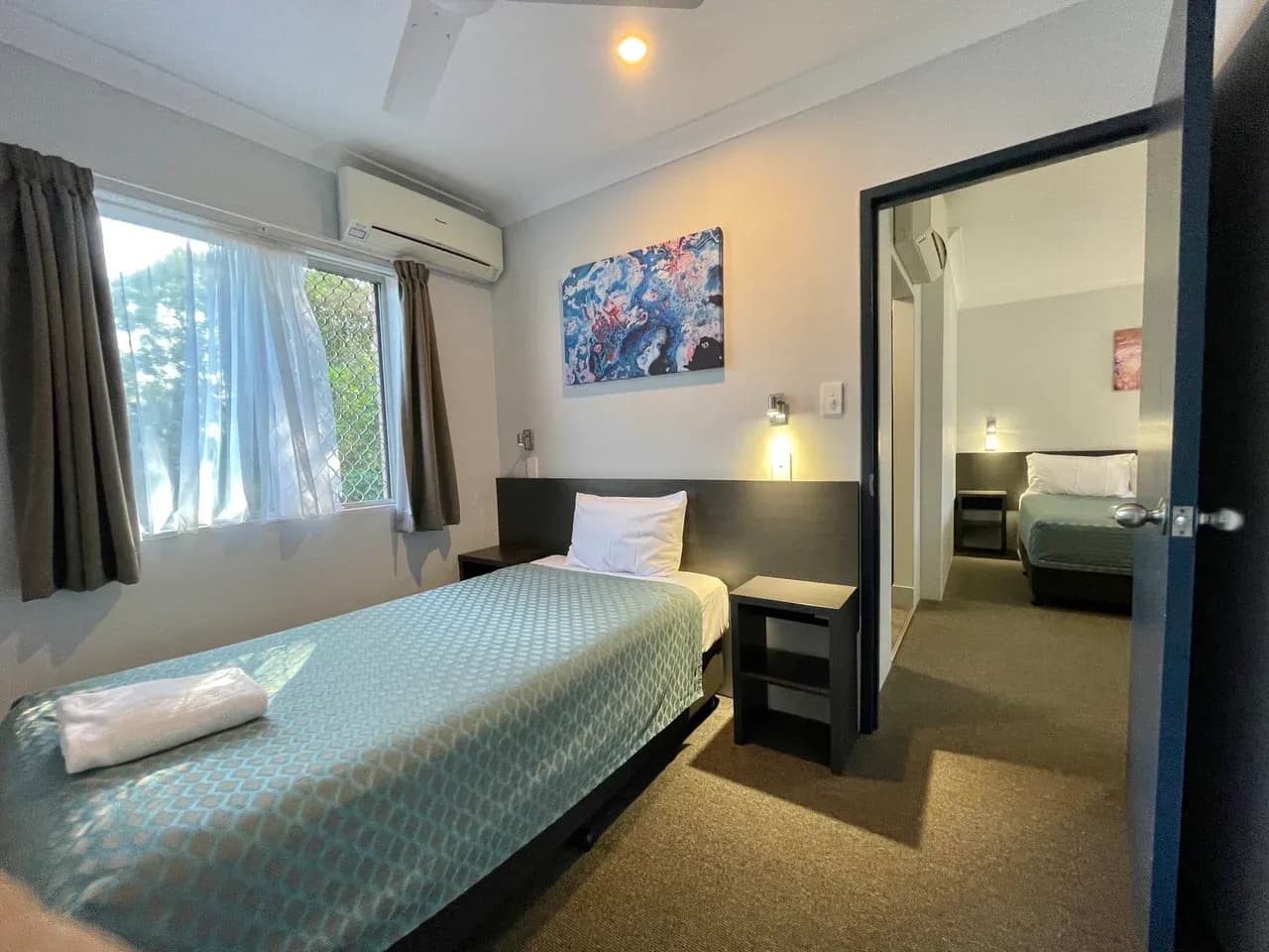 Separate furnished bedrooms with an open connecting doorway at accommodation in Grafton, New South Wales, Australia