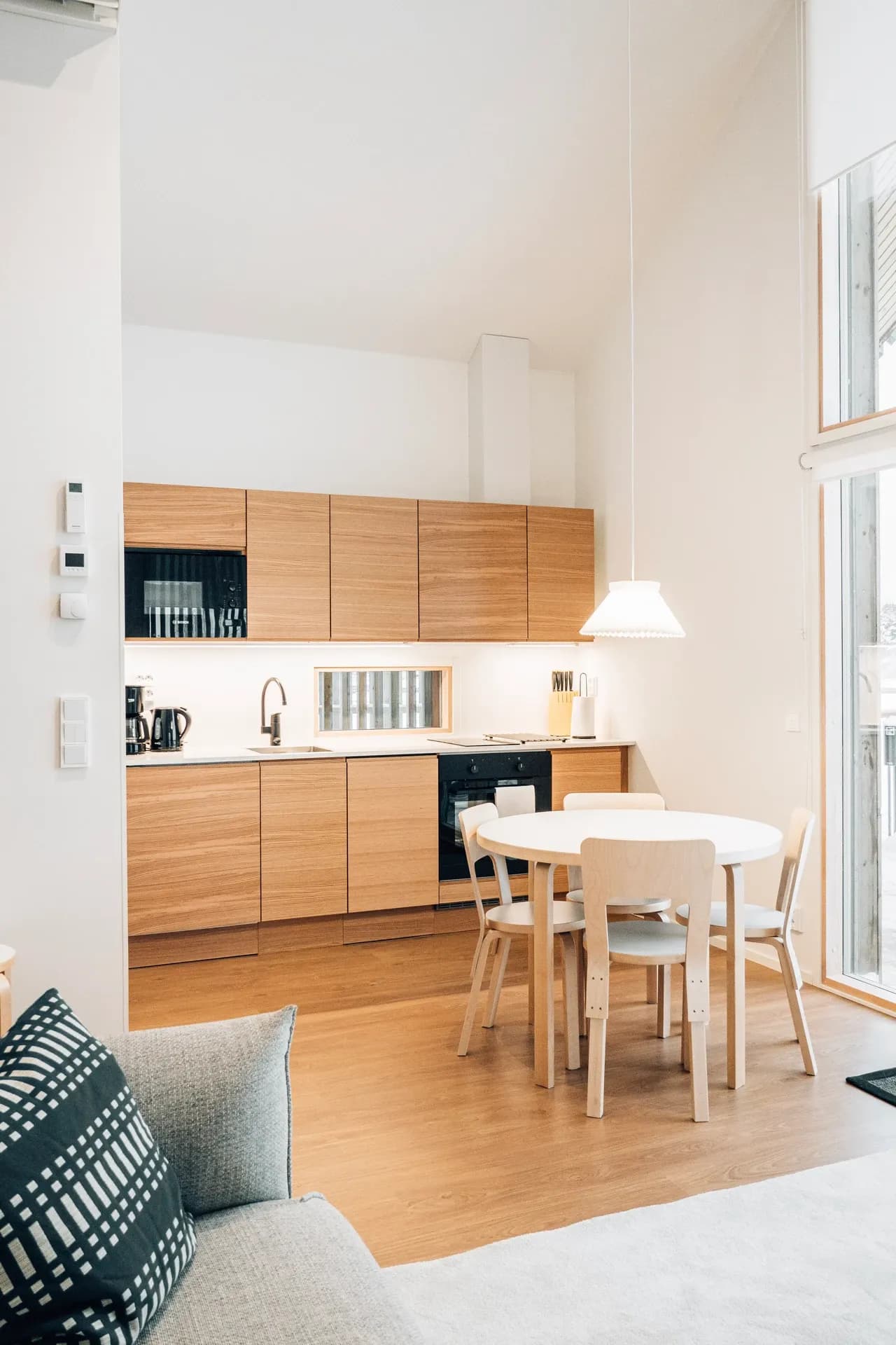 Kitchen and dining space with white cabinets and a wooden table in Finland