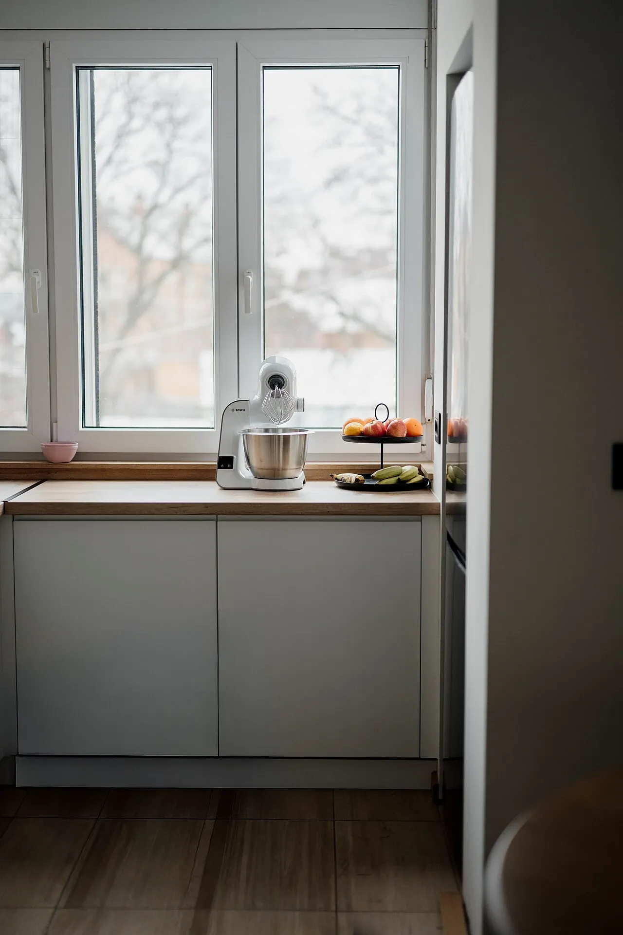 Kitchen counter and large window with snow visible outside