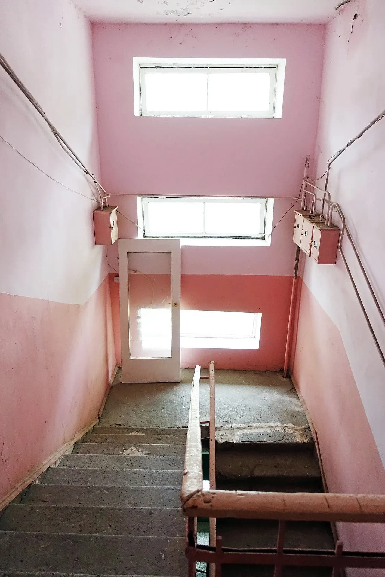 Pink-painted apartment stairwell with railings in Alaverdi, Armenia