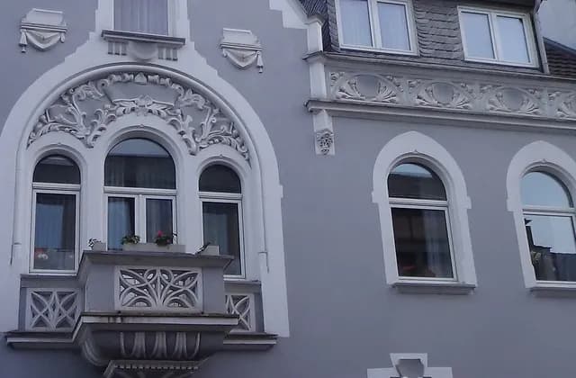 Upper windows and balcony of a residential facade in Bad Honnef, Germany