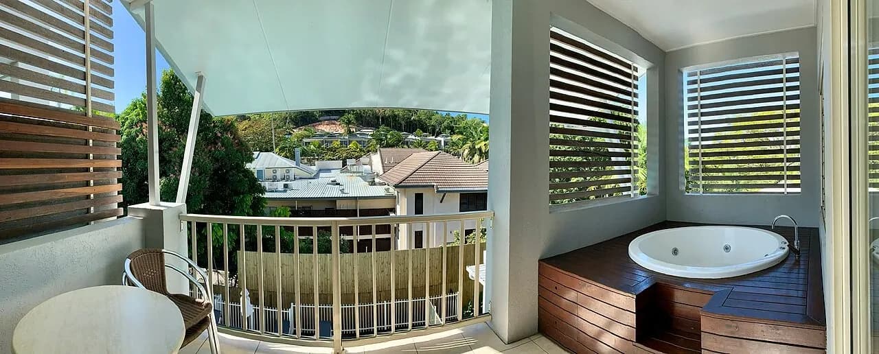 Covered balcony with a table at accommodation in Port Douglas, Australia