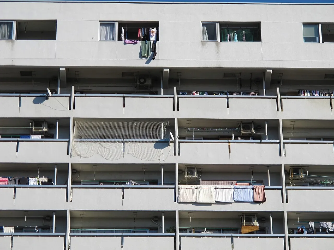 Rows of apartment balconies with household items in Sapporo, Japan