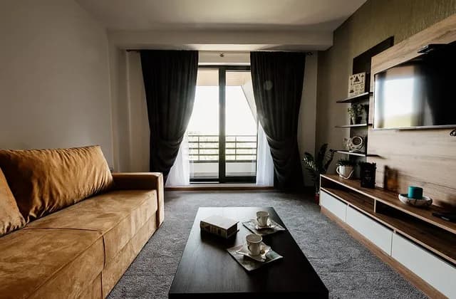 Sofa, coffee table and large windows in a furnished living room