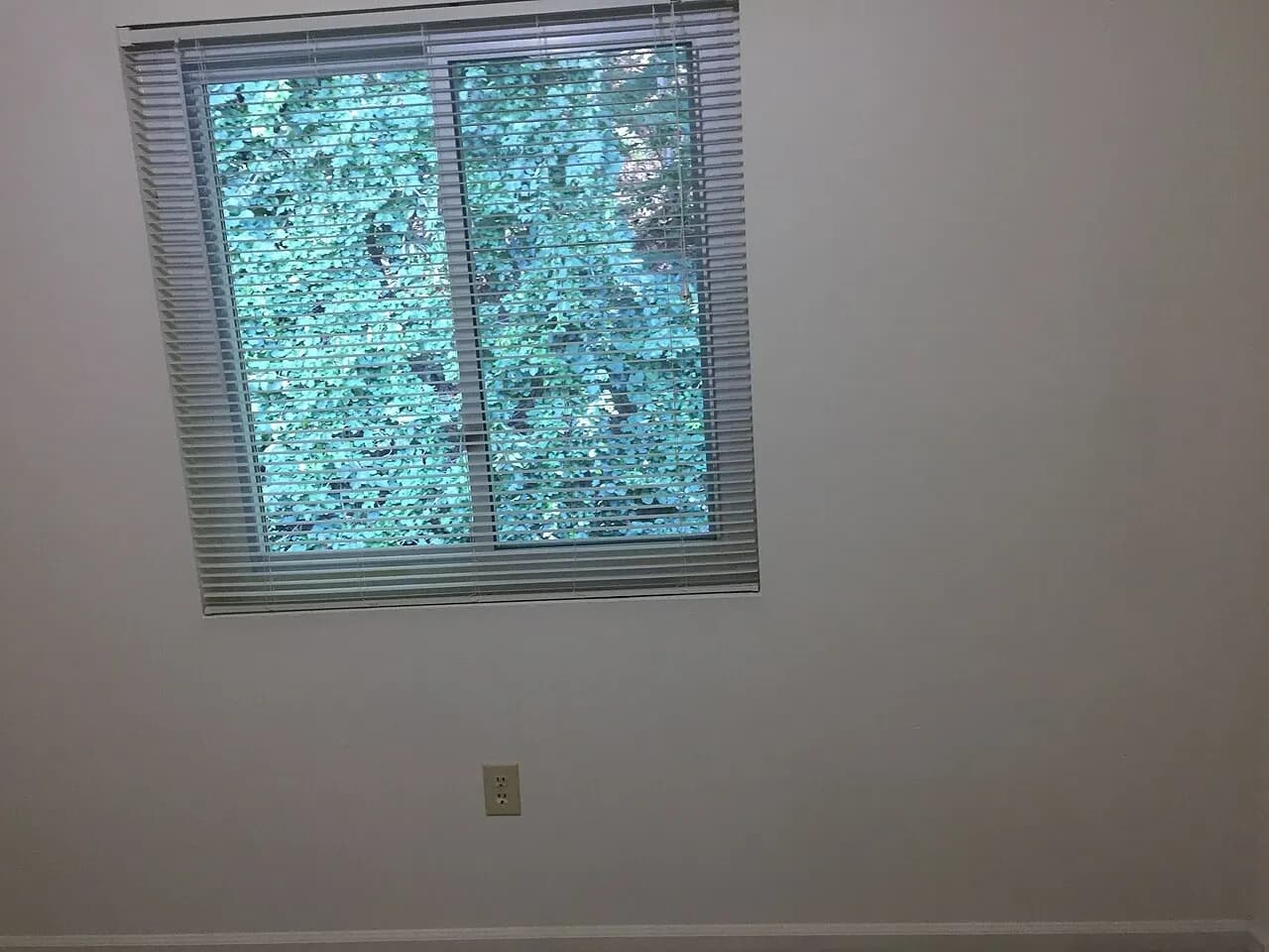Window with blinds in an unfurnished apartment room