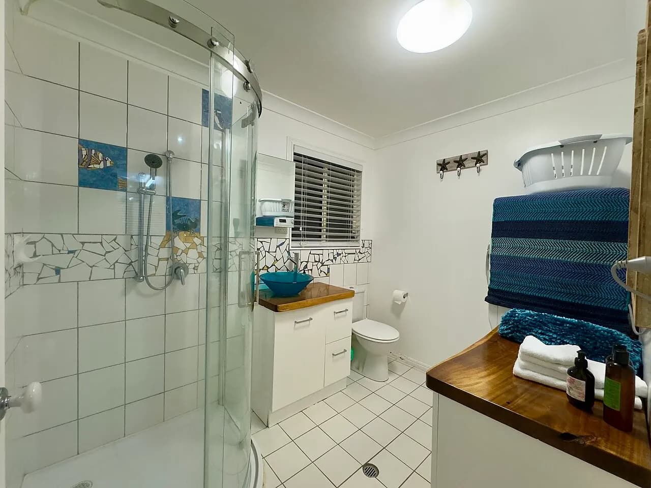Bathroom with shower, vanity and stacked towels at accommodation in South Mission Beach