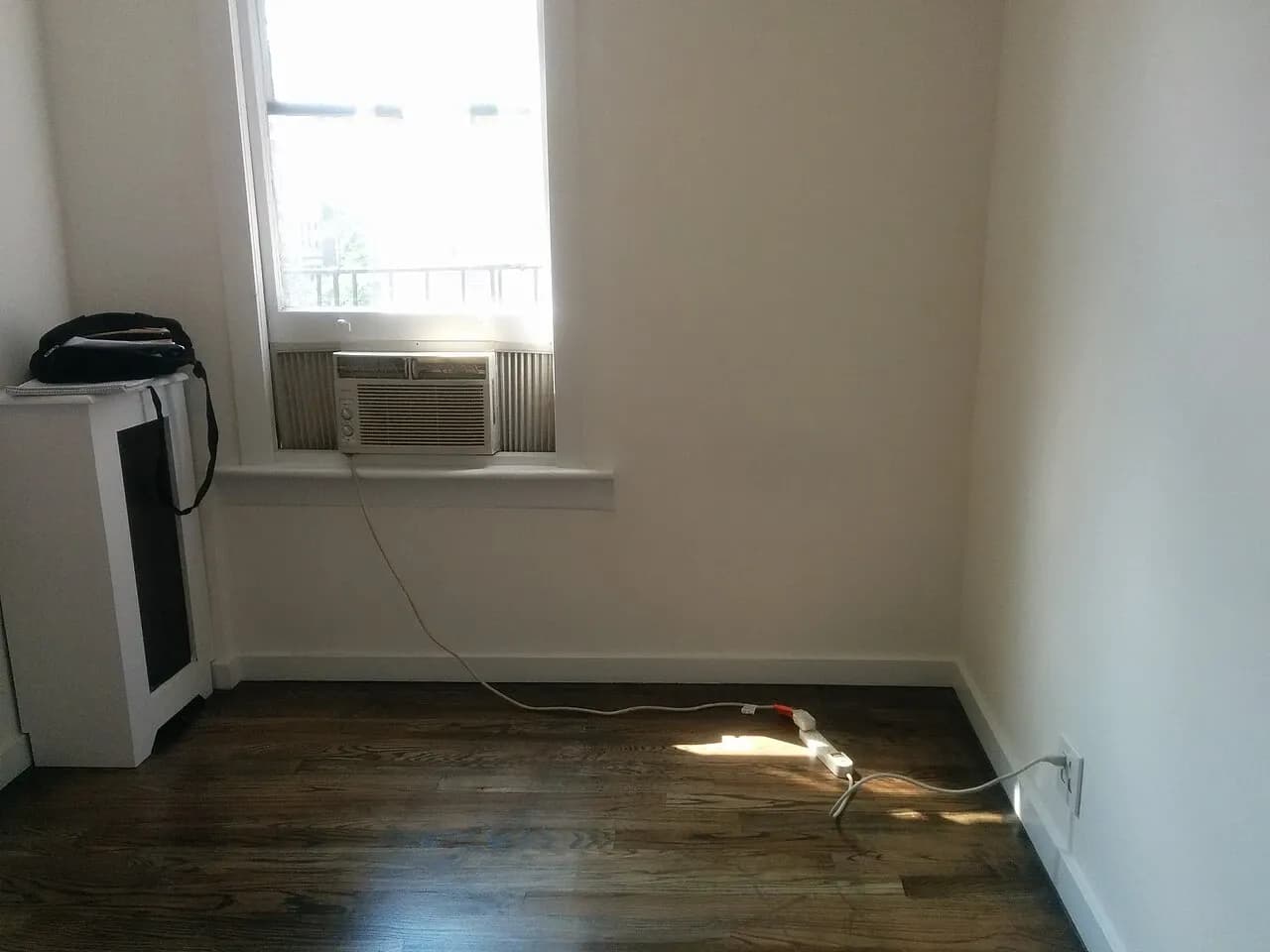 Unfurnished room with a window air conditioner and visible extension cable