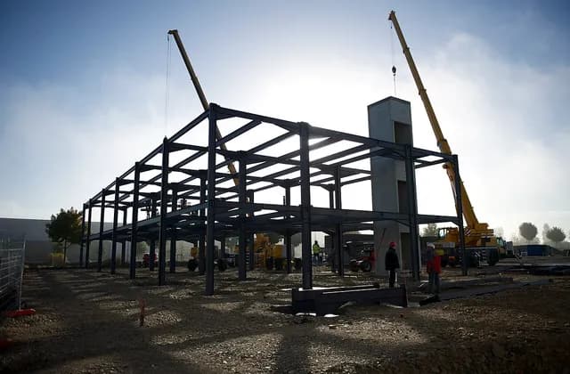Steel frame, construction equipment and a crane at a building site