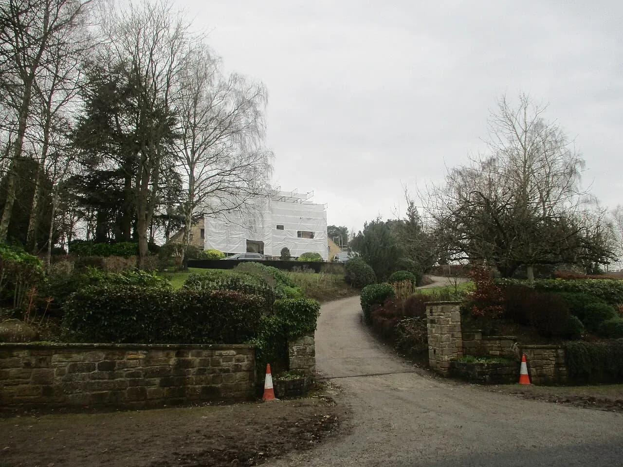 House wrapped for renovation with a driveway approach in Linton, West Yorkshire