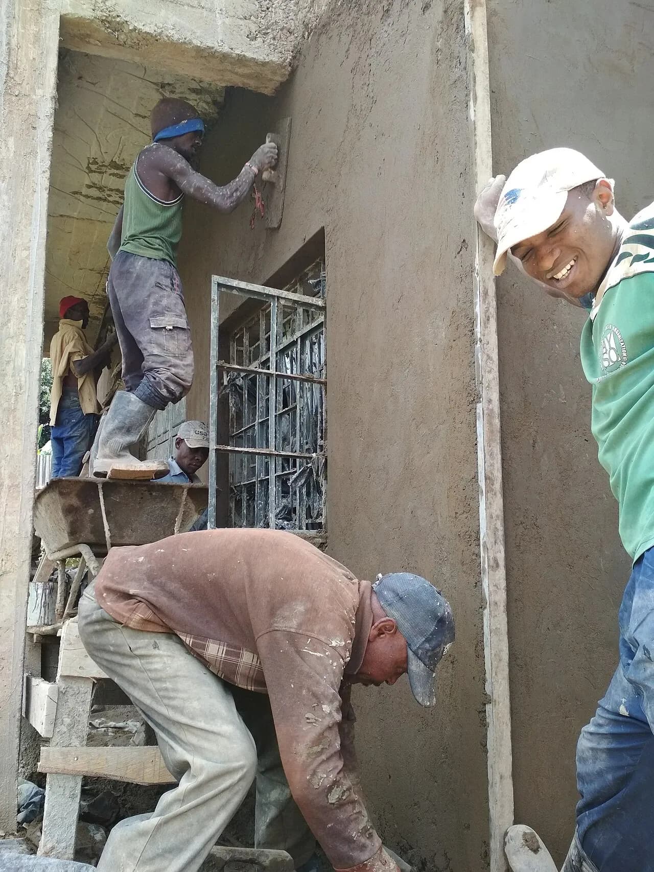 Workers applying material to walls at a residential construction site
