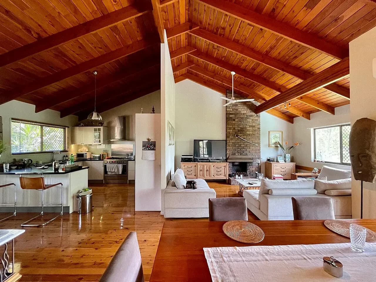 Open kitchen and sitting area with a wooden ceiling in a Corinda house, Australia