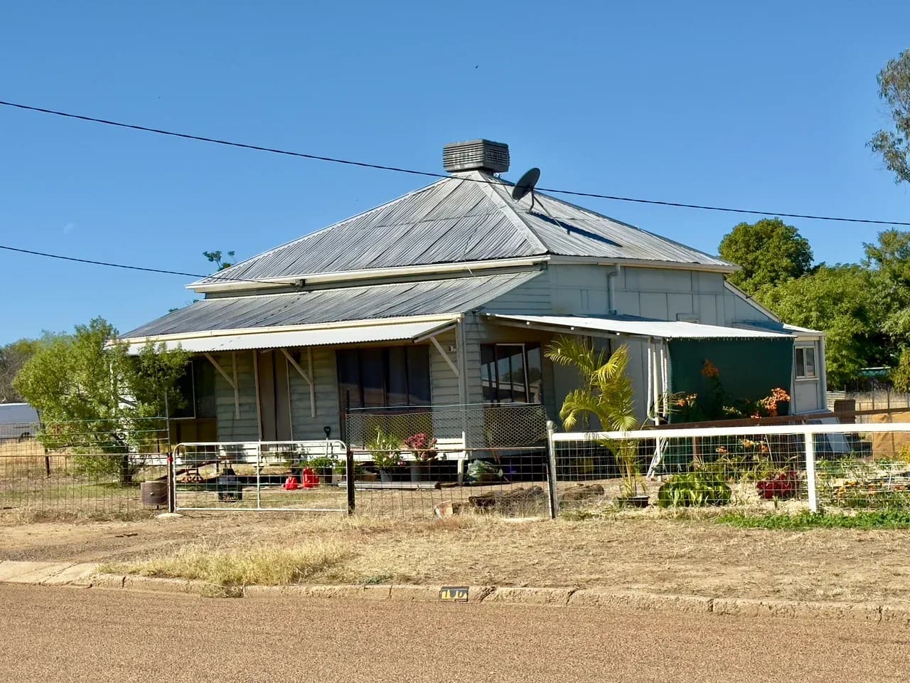 House with a veranda, metal roof and fenced front yard in Longreach, Queensland, Australia